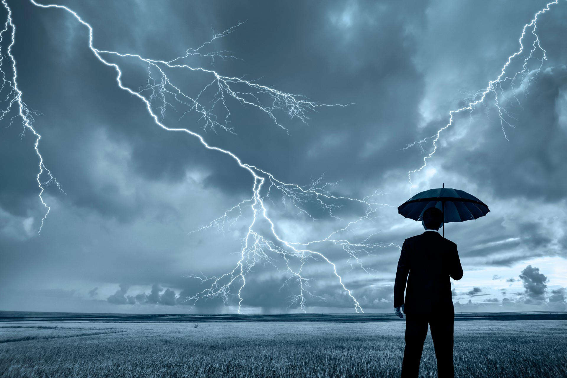 Man in black suit with a black umbrella in a storm